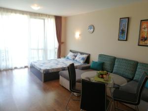 ein Wohnzimmer mit einem Bett und einer Couch in der Unterkunft Apartments Atia Resort in Tschernomorez + 32 Fotos