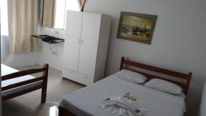 ein Schlafzimmer mit einem Bett, einem Schrank und einem Telefon in der Unterkunft hotel praia itapua in Salvador