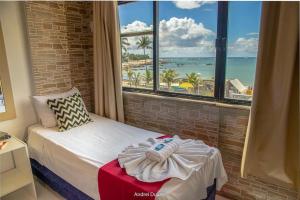 ein Schlafzimmer mit einem Bett mit Blick auf den Strand in der Unterkunft hotel praia itapua in Salvador