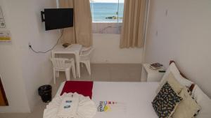 ein Schlafzimmer mit einem Bett und einem Tisch und einem Fenster in der Unterkunft hotel praia itapua in Salvador