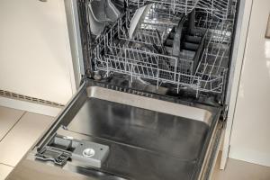 a dishwasher with a dish rack inside of it at Comfy & stylish 4 bed house in Bedford +78 photos