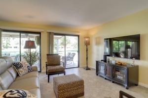 a living room with a couch and a tv at Golf Course Condo with Patio in Cathedral City! in Cathedral City