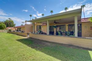 a house with palm trees in the background at Golf Course Condo with Patio in Cathedral City! in Cathedral City