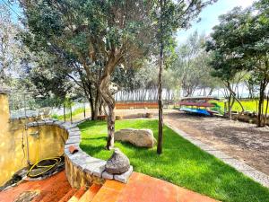 a park with a pond and a tree and a train at Le Corti Sarde On The Beach in Bari Sardo