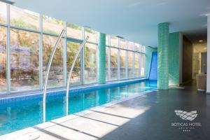 a swimming pool in a building with windows at Boticas Hotel Art & SPA in Boticas