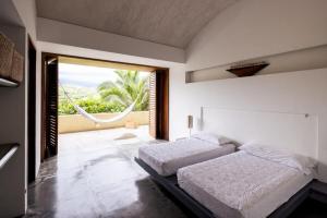 アナポイマにあるSparkling 3BR Villa with Pool at Mesa de Yeguasのベッドが2つと大きな窓がある寝室