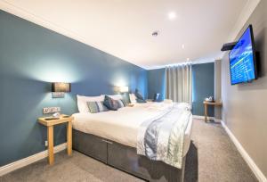 a bedroom with a large bed and a flat screen tv at Dolphin Rooms in Cleethorpes