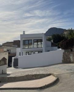 ein weißes Haus mit einem weißen Zaun davor in der Unterkunft Villa La Fuente in Periana