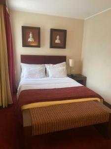 a bedroom with a large bed with two pictures on the wall at Hotel Apartamento Vila Galé Cascais T1 248 in Cascais