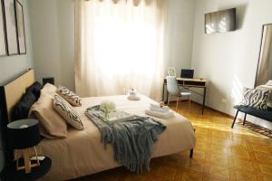 a bedroom with a bed with a desk and a window at Maria Pia apartment in Borghesiana 