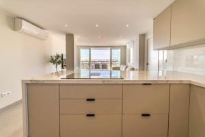 トレビエハにあるFrontline Apartment Sea Views - Pool - Centerの白いキャビネットと大きな窓のあるキッチン