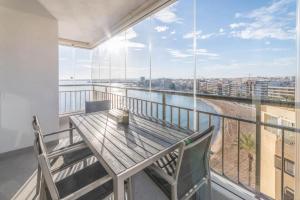 トレビエハにあるFrontline Apartment Sea Views - Pool - Centerの木製テーブルと椅子2脚付きのバルコニー
