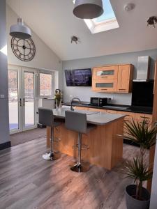 a kitchen with a kitchen island with two bar stools at Wend Gardens Studio Carleton Skipton Pet Friendly in Skipton