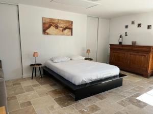a bedroom with a bed and a wooden dresser at Villa Hésperides 5 mins de Disneyland Paris in Magny-le-Hongre