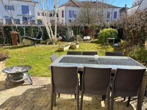 a table with four chairs and a table and a table and chairsktop at Villa Hésperides 5 mins de Disneyland Paris in Magny-le-Hongre