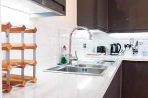 cocina con fregadero de acero inoxidable y estante en Charlotte House Spacious 2br 2bath In Ipswich, en Ipswich