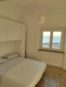 サヴォーナにある4 Finestre sul mareのベッドと窓のある寝室 +4枚の写真