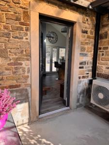 a door leading into aoyer with a brick wall at Wend Gardens Studio Carleton Skipton Pet Friendly in Skipton +29 photos