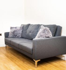 un sofá gris sentado en una sala de estar en Charlotte House Spacious 2br 2bath In Ipswich, en Ipswich 3 fotos más