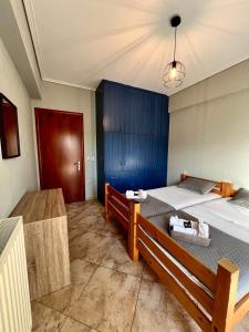 a bedroom with two beds and a blue cabinet at Alexios Aparments in Néa Seléfkeia