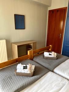 two beds in a room with towels on them at Alexios Aparments in Néa Seléfkeia