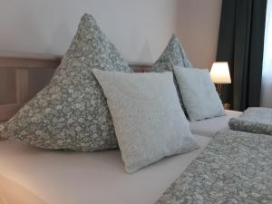 a bed with four pillows on top of it at Ferienwohnung Pölzl in Chieming