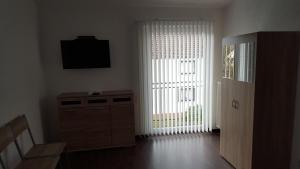 un salon avec une grande fenêtre et une télévision dans l'établissement Appartements Vermietung, à Industriehof