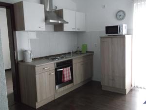 a kitchen with a stove and a microwave at Appartements Vermietung in Industriehof