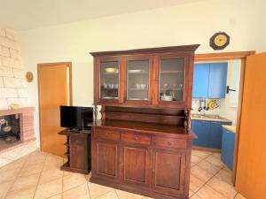 una cocina con un gran armario de madera con microondas en Villa del Moro - Ostuni - Beach & Relax, en Villanova di Ostuni 72 fotos más