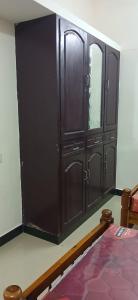 a large wooden cabinet in a room with a bed at Eastville Homestays in Trivandrum