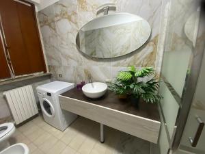 ein Badezimmer mit Waschbecken und Spiegel in der Unterkunft Two-room apartment in Voghera's historic center in Voghera