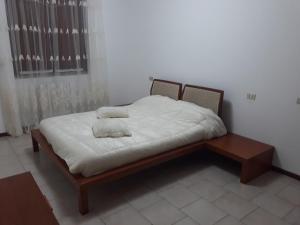 ein Bett mit weißen Laken und Kissen darauf in der Unterkunft Two-room apartment in Voghera's historic center in Voghera