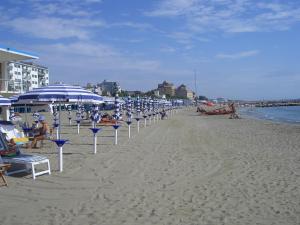 un grupo de sillas de playa y sombrillas en una playa en Hotel Sorriso, en Lido de Venecia