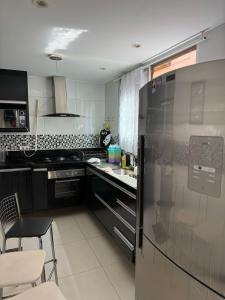 a kitchen with a refrigerator and a table and chairs at Itapuã - 4 Minutos da Praia - Quarto com Suíte in Vila Velha +30 photos