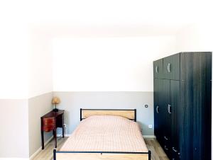 a bedroom with a bed and a wooden cabinet at Gîte au calme de la campagne, jardin, billard, parking in Écury-sur-Coole