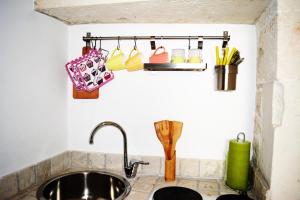 a kitchen sink with utensils on a wall at Martine Dimore Storiche di Puglia in Martina Franca