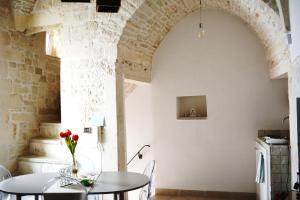 a dining room with a table and a brick wall at Martine Dimore Storiche di Puglia in Martina Franca