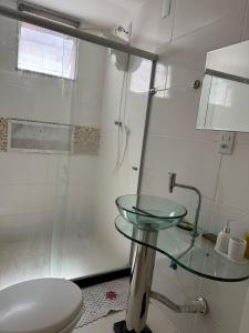 a bathroom with a glass sink and a toilet at Itapuã - 4 Minutos da Praia - Quarto com Suíte in Vila Velha