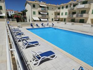 a swimming pool with lounge chairs next to a building at Via Bachelet 8 Luxury House in Civitanova Marche