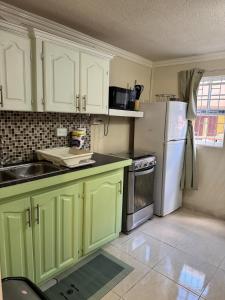a kitchen with green cabinets and a white refrigerator at Westview 4 in Saint James