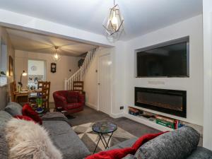 a living room with a couch and a flat screen tv at Colliers Cottage in Cinderford