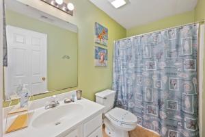 a bathroom with a toilet and a shower curtain at 53C Tee to Sea condo in Pawleys Island +9 photos