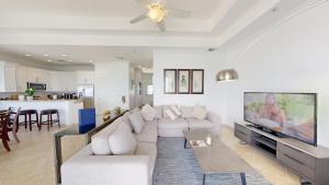 ein Wohnzimmer mit Sofa und Fernseher in der Unterkunft South Bay Beach Club #37 Penthouse - 3 Bedroom 3 Bathroom Unit in George Town