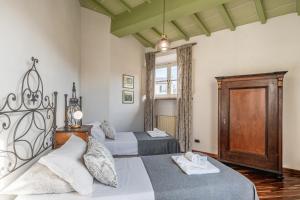 Un dormitorio con dos camas y una ventana. en Busdraghi Luxury Apartment, en Lucca