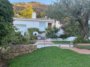 a white house with a bench in a yard at Villa Loupiro in Mijas