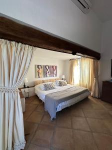a bedroom with a large bed and curtains at Villa Loupiro in Mijas
