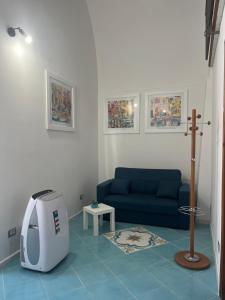 a living room with a blue couch and a tv at Casa MiraMare in Procida