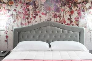 a bedroom with a white bed with a floral wallpaper at B&B Golden House & spa in Rose