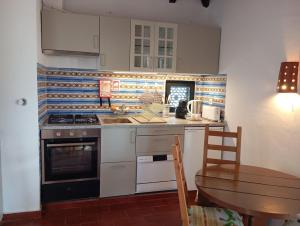 een keuken met een fornuis en een houten tafel bij Pedras Del Rei I in Tavira