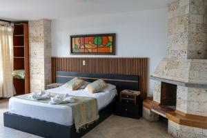 una camera da letto con un letto e un camino di Hotel Portal Guatapé a Guatapé
